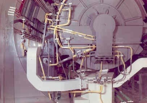 Große industrielle Beschleunigermaschine mit mehreren angeschlossenen Komponenten innerhalb eines Gebäudes.