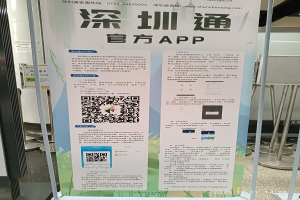 Ein Banner mit einem QR-Code vor einem Gebäude, wahrscheinlich für den Shenzhen International Airport, umgeben von Ständen und Tafeln.