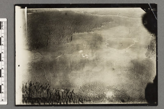 Schwarzes und weißes Foto eines Stausees, der von Bäumen umgeben ist, mit einer Skala auf der linken Seite.