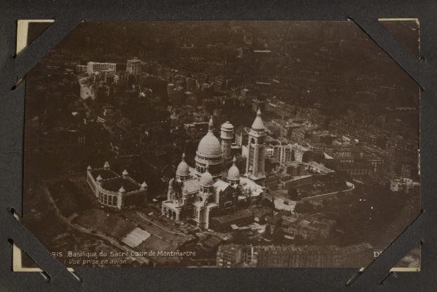 Altes Schwarz-Weiß-Foto einer Stadt mit einem großen zentralen Gebäude, umgeben von anderen Gebäuden.