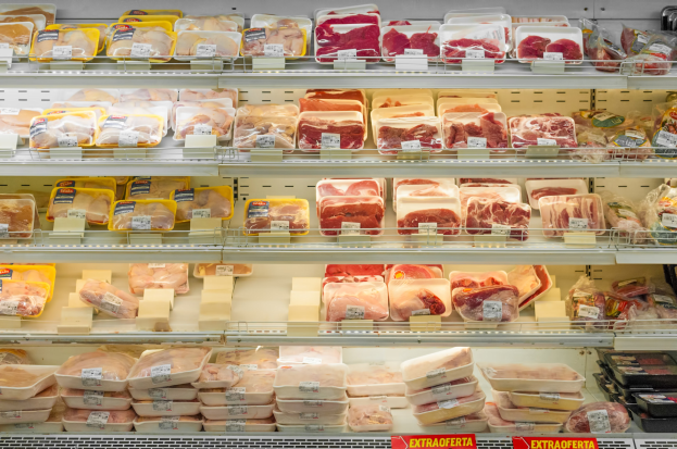 Ein gut organisierter Supermarktregal mit verschiedenen Arten von ordentlich angeordnetem Fleisch mit sichtbaren Preisschildern.