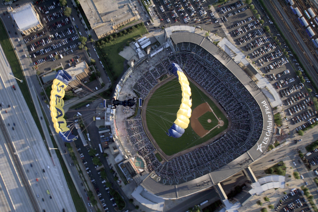 Luftbild eines Baseball-Stadions mit zwei Paragleitern darüber, umgeben von Gebäuden, Bäumen, Straßen, Fahrzeugen und Gras.