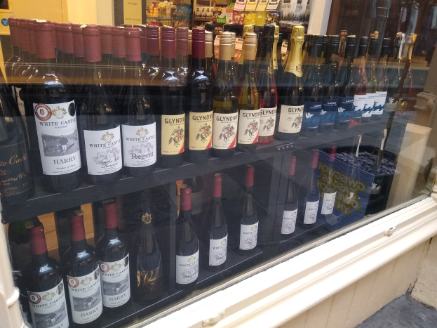 Vitrine mit verschiedenen Weinflaschen, jede mit sichtbarem Etikett, in einer Umgebung, die an einen Weinladen erinnert.