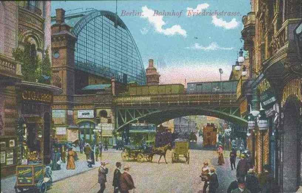 Alte Postkarte zeigt eine belebte Straßen Szenerie in Berlin, Deutschland, mit Fußgängern, Pferdefuhrwerken, Gebäuden, Laternen, einer Brücke und einem bewölkten Himmel, mit Text oben.