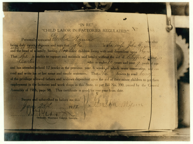 Schwarzes und weißes Bild eines alten Dokuments mit der Überschrift "Kinderaortuntersuchungsbescheinigung" mit handgeschriebener Text.