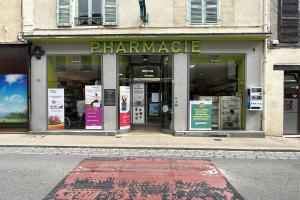 Apotheke mit Glaswänden und -türen, Plakate an den Innenwänden, befindet sich an einer Straßenkreuzung mit einer Straße unten.
