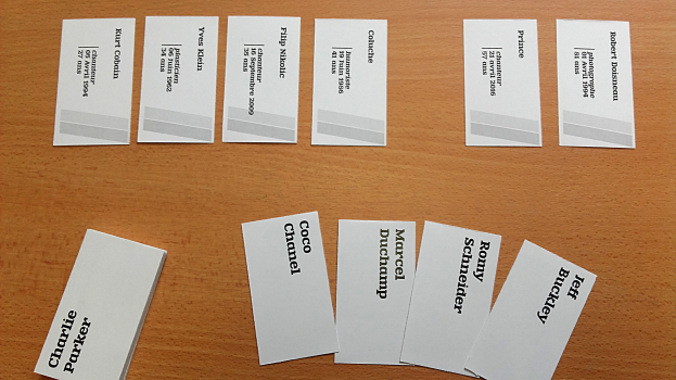 Ein Holztisch mit einer Sammlung von weißen Visitenkarten mit gedrucktem Text.