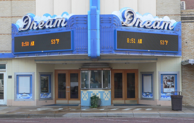 Außenansicht des Dream Theaters in St. Louis, Missouri, mit Glasfenstern und -türen, einem Namensschild, einem Mülleimer, einem Topf mit einer Pflanze und einer Straße unten.