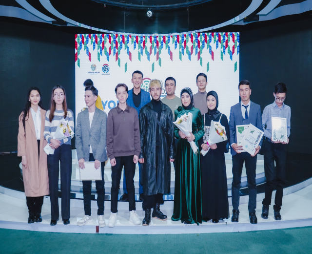 Gruppe von Menschen auf einer Bühne mit Blumensträußen und Urkunden, vor dem Hintergrund "Youth Solar Awards 2019"